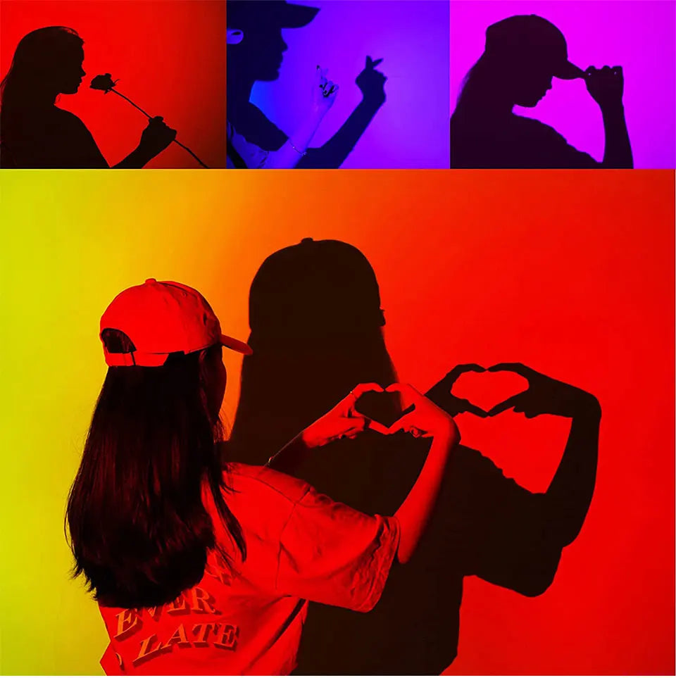 Smart LED projection lamp casting vibrant sunset-style colour gradients and silhouettes of people onto a wall.