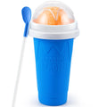 Blue squeeze slushy maker cup with a white lid, clear dome, orange slushy inside, and a blue spoon-straw.