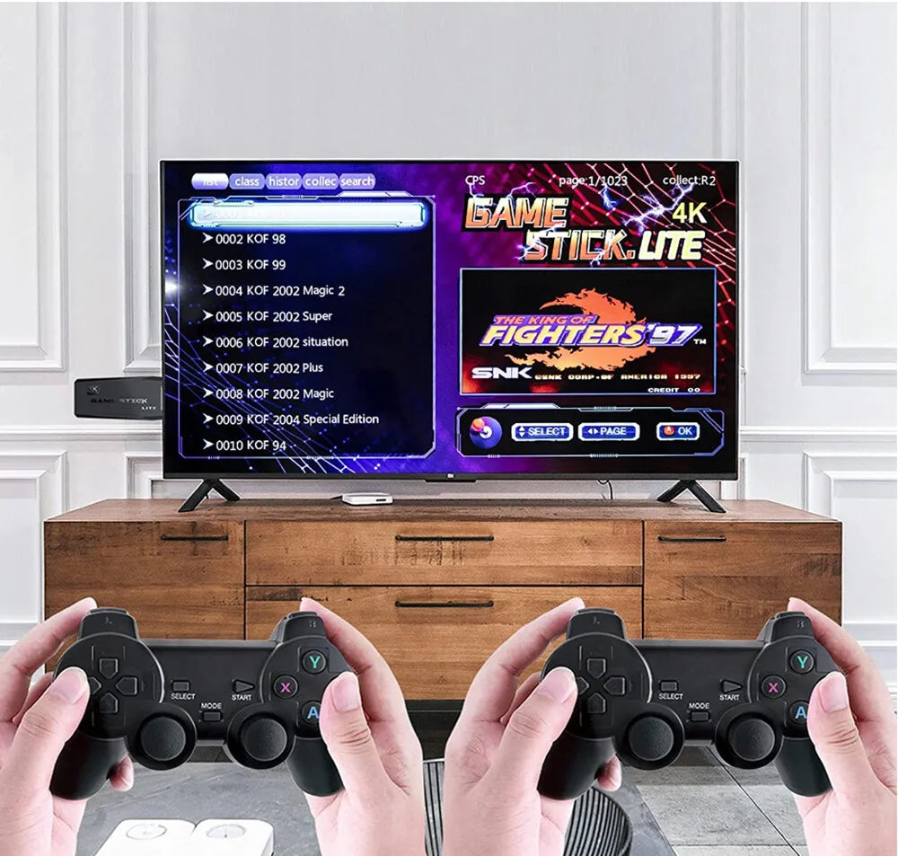 Two black wireless controllers held in hands, with a retro game menu displayed on a large TV screen.