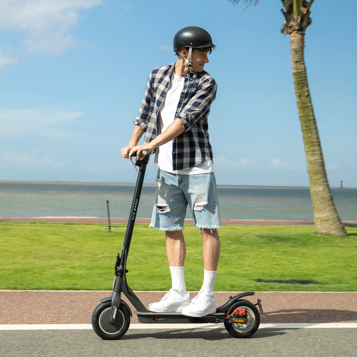 Black 5TH WHEEL V30Pro electric scooter with 10-inch tires and rear suspension, ridden by man outdoors.