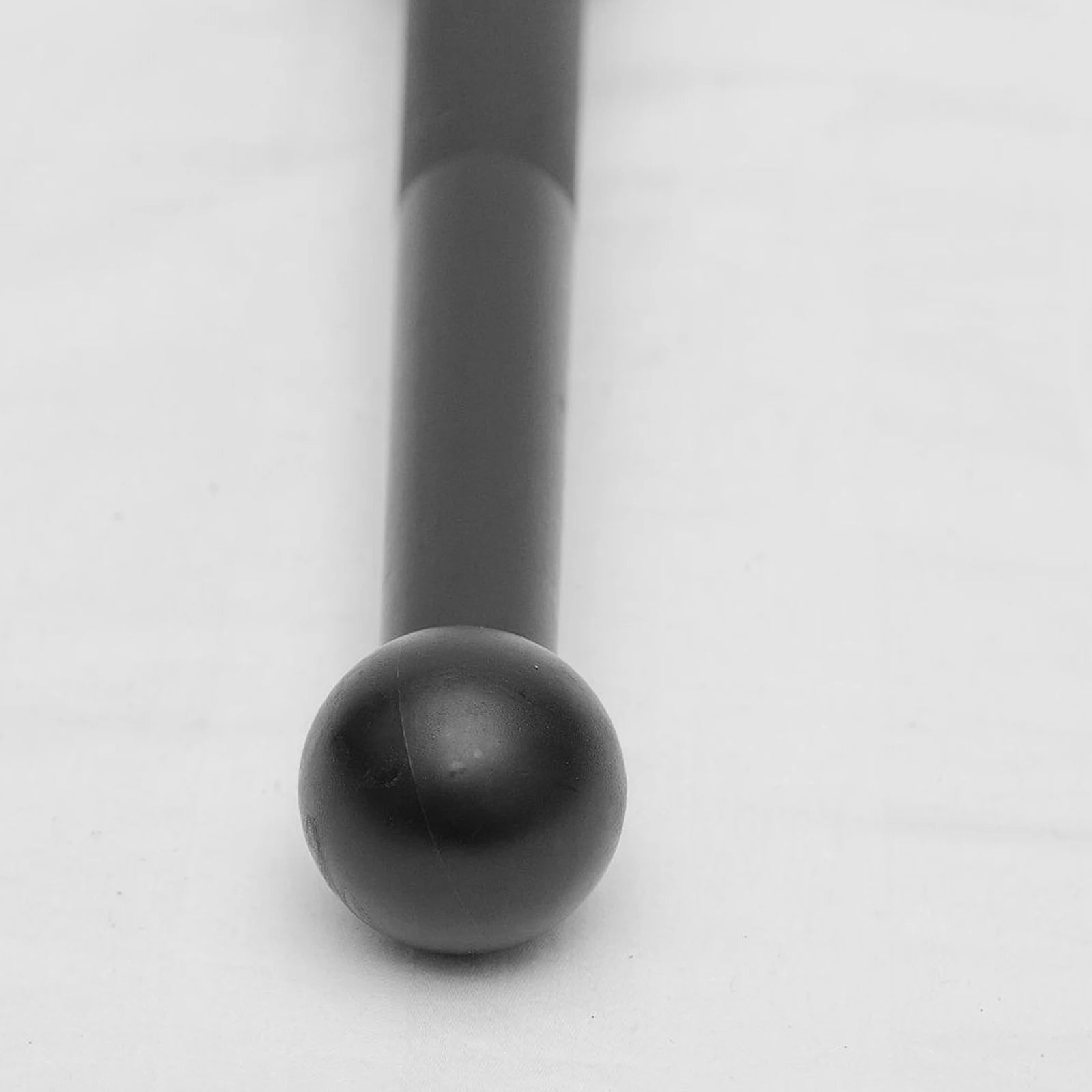 Matte black Indian clubbell with a smooth spherical end and cylindrical handle, set against a plain light background.