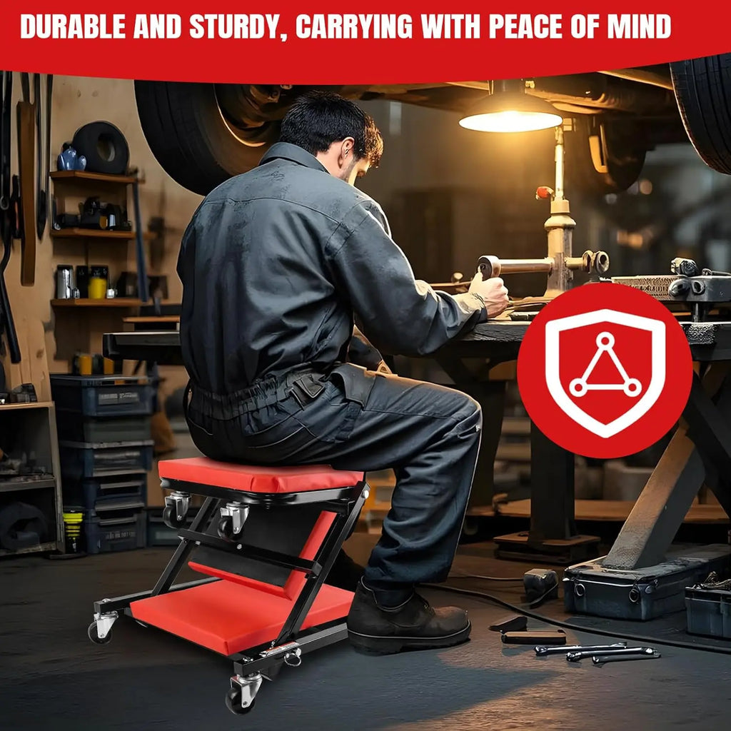 Mechanic seated on a folding red and black 2-in-1 car creeper and stool with swivel wheels in a garage.