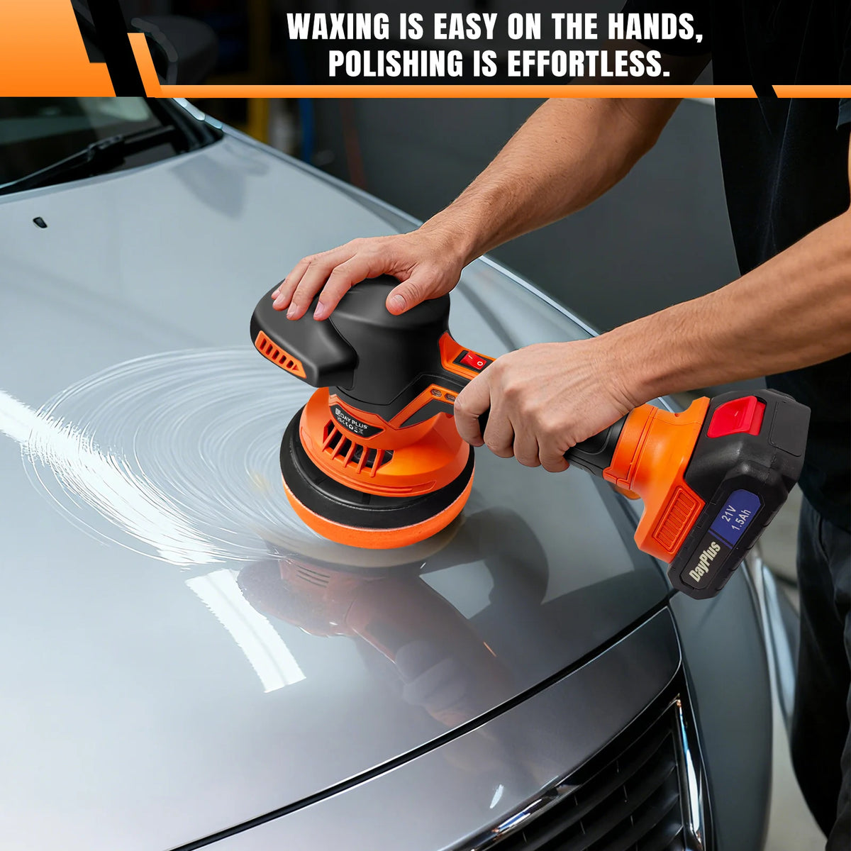 Orange and black cordless car polisher buffing the hood of a silver car.