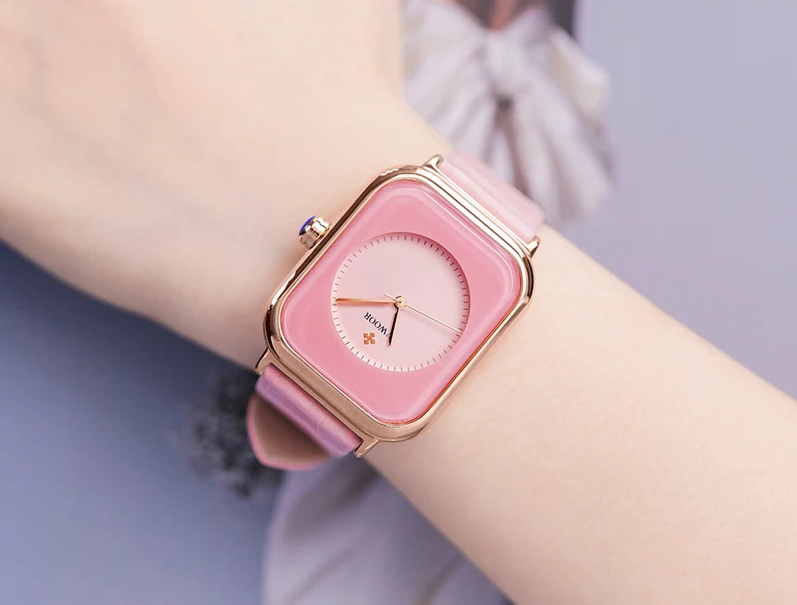 Ladies' watch with a pink leather strap, rose-gold square case, and minimalist pink round analogue dial.
