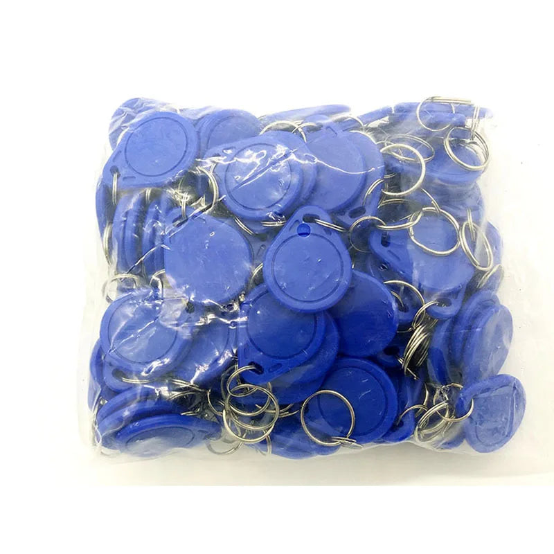 Bulk pack of blue plastic RFID key fob tags with metal key rings inside a clear plastic bag.