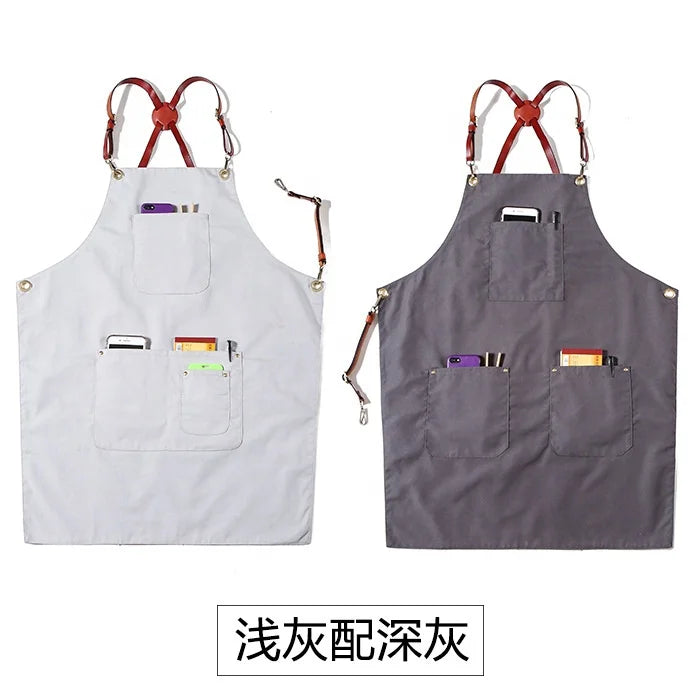 Light grey and dark grey canvas work aprons with multiple pockets and adjustable leather cross-back straps.