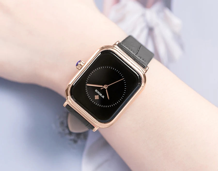 Ladies' square watch with a rose gold case, black dial and a textured black leather strap.