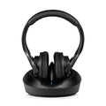 Black wireless TV headphones with cushioned ear cups, sitting on a sleek charging transmitter base.