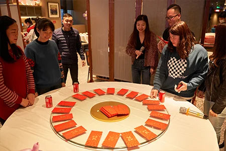 The provided image does not show a laptop backpack; it depicts a group of people gathered around a table with red envelopes.