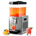 Commercial juice dispenser with stainless steel base and clear tank pouring orange drink into a glass.