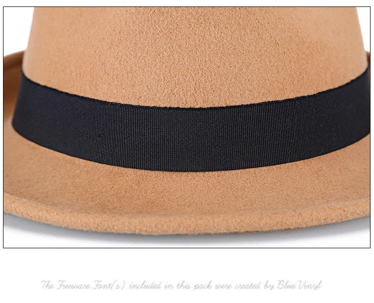 Close-up of a tan wool-felt fedora hat featuring a contrasting black ribbon band.