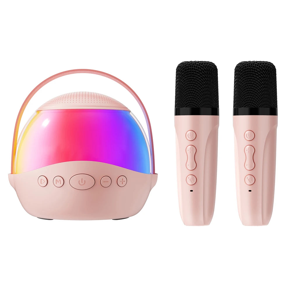 Pink portable karaoke speaker with rainbow LED lighting, a carry handle, and two matching wireless microphones.
