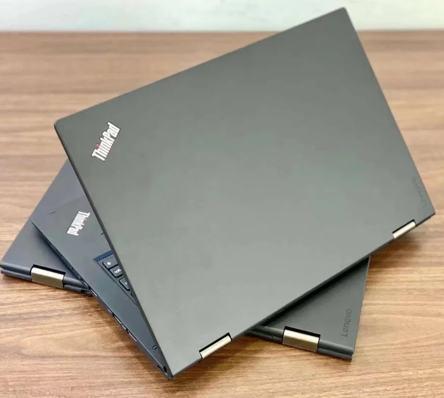 A sleek, dark grey 13.3-inch 2-in-1 touchscreen business laptop shown from different angles on a wooden desk.