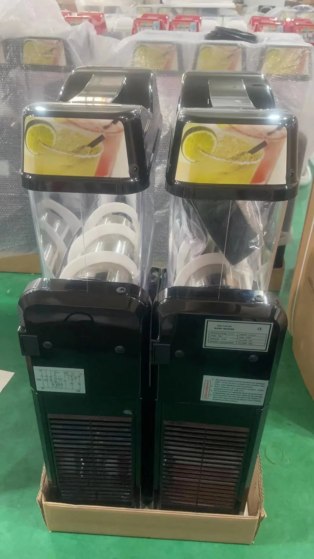 Two professional slush machines with black casing and clear containers, featuring promotional lime drink imagery.
