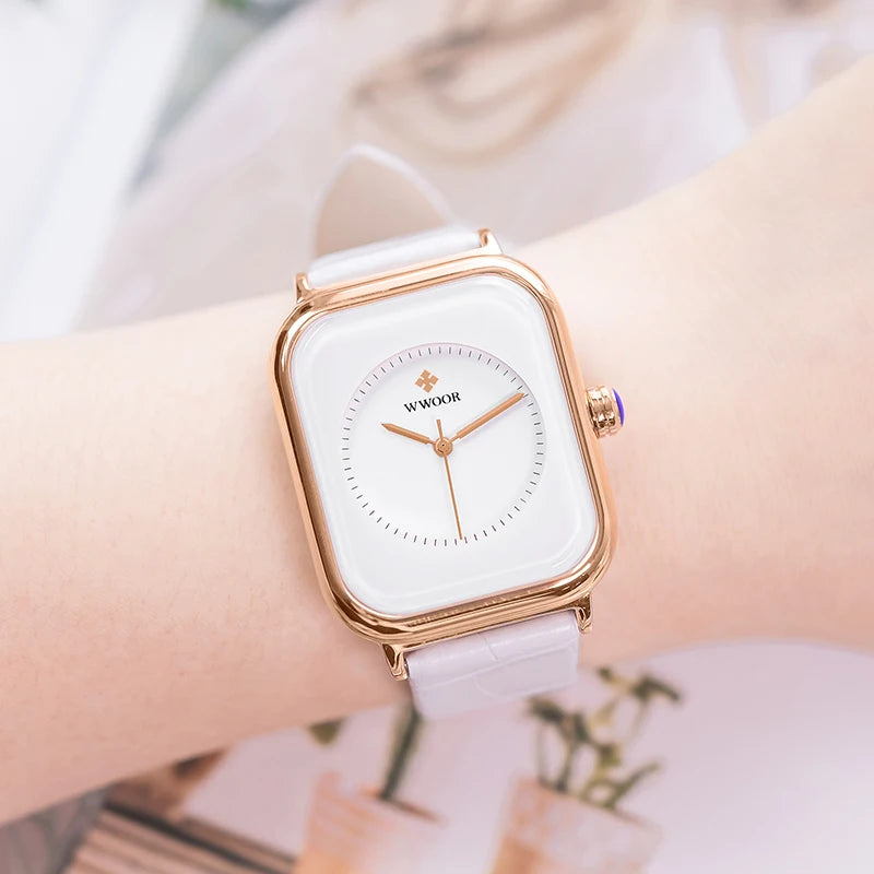 Ladies' watch featuring a square gold-tone case, minimalist white dial, and a slim pale-pink leather strap.