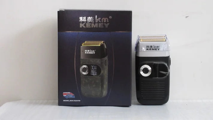 A black rechargeable cordless foil shaver with a digital display, shown next to its product packaging.