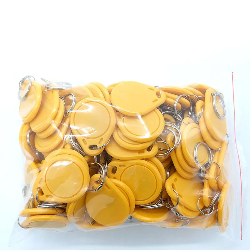 A bag of yellow plastic RFID key fob tags with metal split rings.