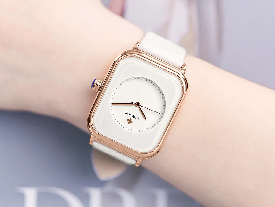 Elegant ladies' watch featuring a square rose-gold case, white dial, and slim white leather strap worn on the wrist.