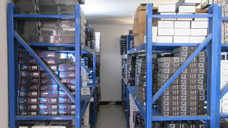 Blue storage racks filled with boxed rechargeable cordless hair clippers and trimmers in a warehouse setting.