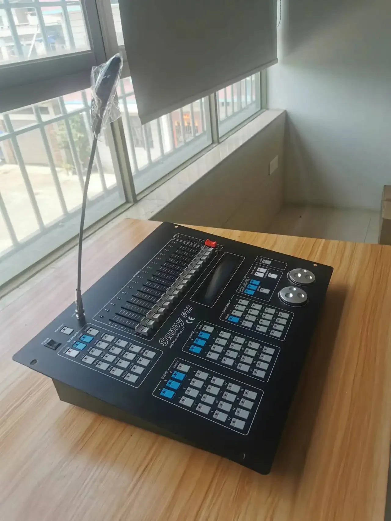 Black 512 DMX lighting controller with faders, buttons, digital display, control wheels, and a gooseneck lamp.