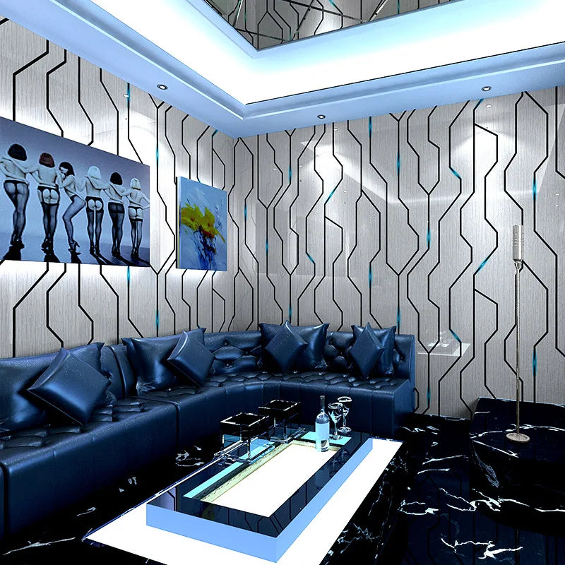 Modern living room with 3D reflective silver wallpaper featuring bold black geometric lines on a feature wall.