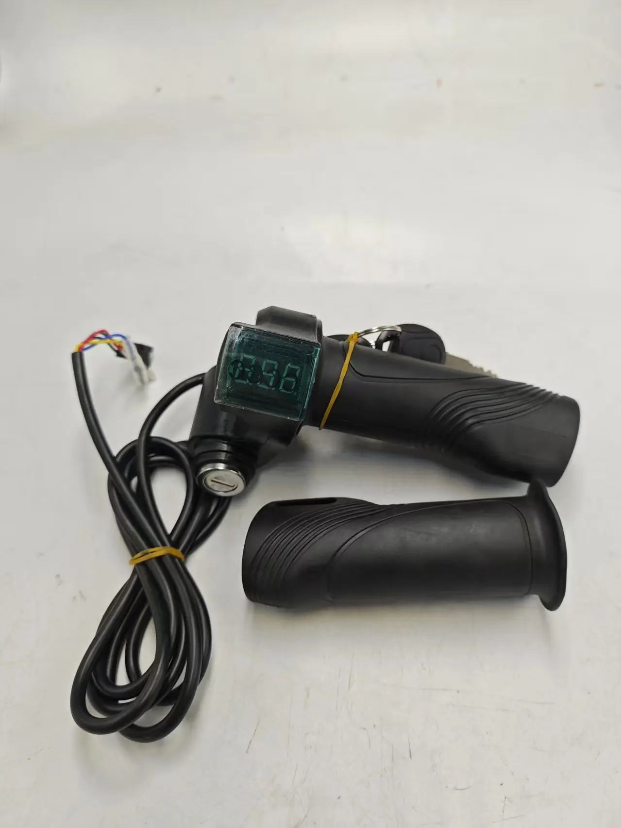 Black electric bike twist throttle set with integrated voltage display screen, ignition key switch, and wiring harness.