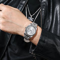 Luxury silver-tone quartz watch with a fluted bezel, crystal hour markers, and a link bracelet on a wrist.