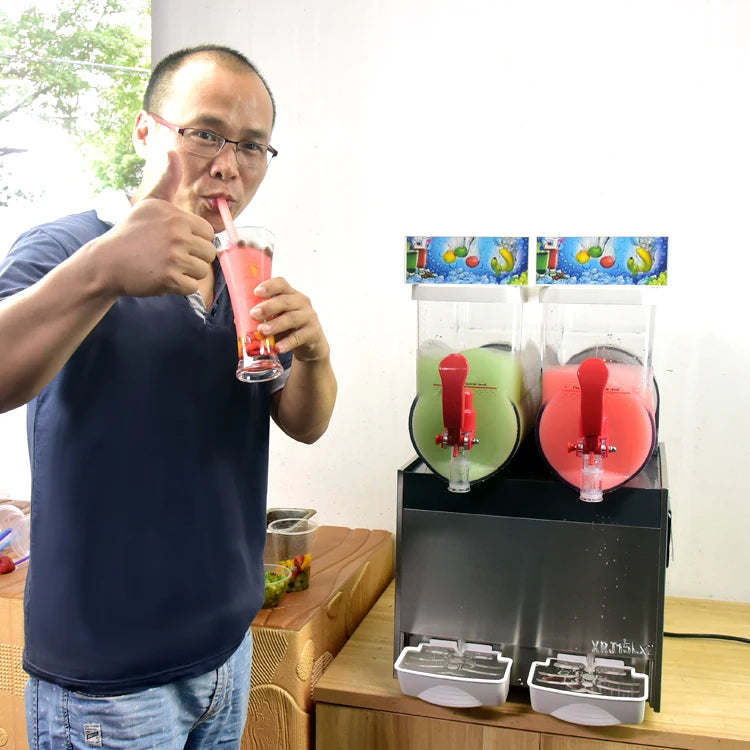 Commercial 2-bowl stainless steel slush machine with red levers and clear tanks holding green and red frozen drinks.