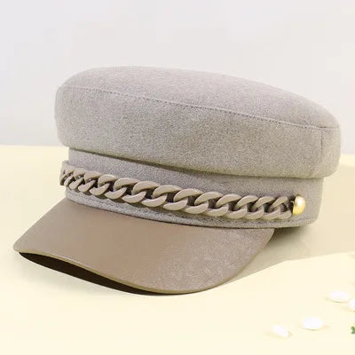 Beige felt baker boy cap featuring a decorative matching-tone chain and gold-tone side detail.