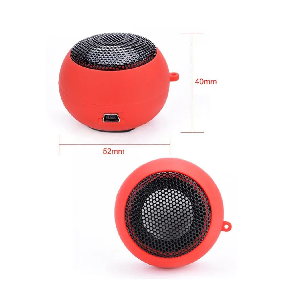 Small, spherical red portable speaker with a black metal grille and side charging port, measuring 52mm by 40mm.