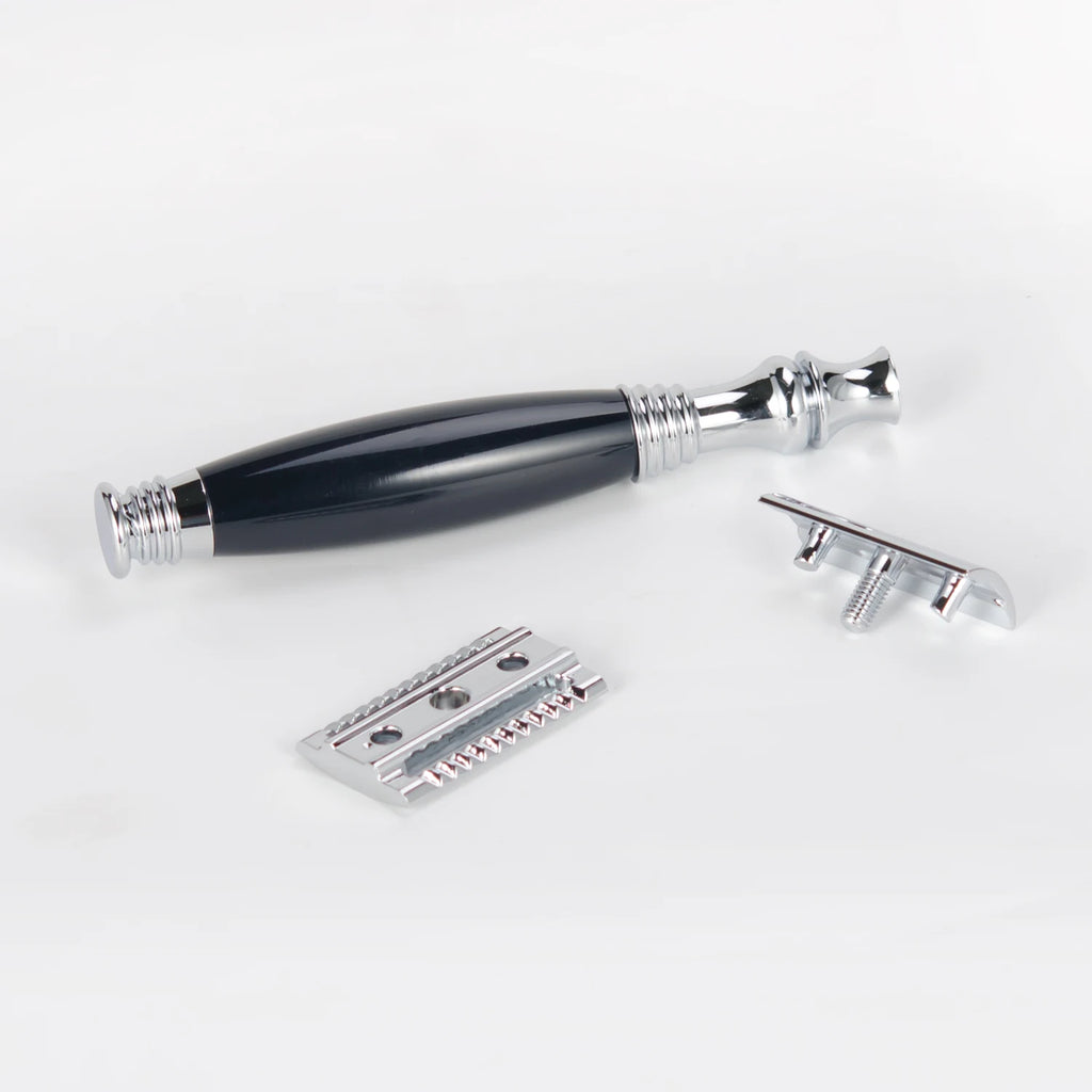 Traditional safety razor with a chrome and black handle, shown disassembled into three parts against a white background.