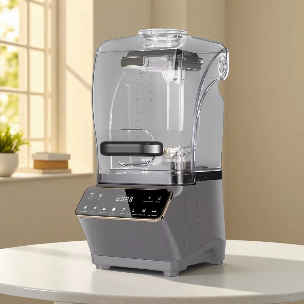 Modern grey blender with a clear sound-dampening cover and a digital touch display, sitting on a white table.