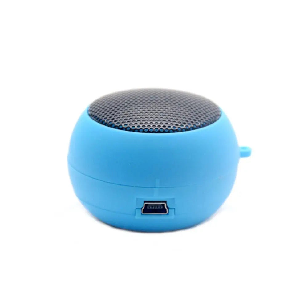 Small, spherical, bright blue portable Bluetooth speaker with a black metal grille and charging port.