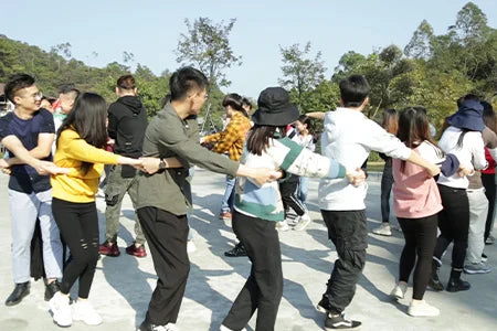 The provided image does not show a backpack; it shows a group of young people holding hands in a line outdoors.