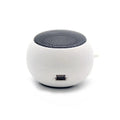 Small, spherical white portable speaker with a black mesh top and a visible charging port on the side.