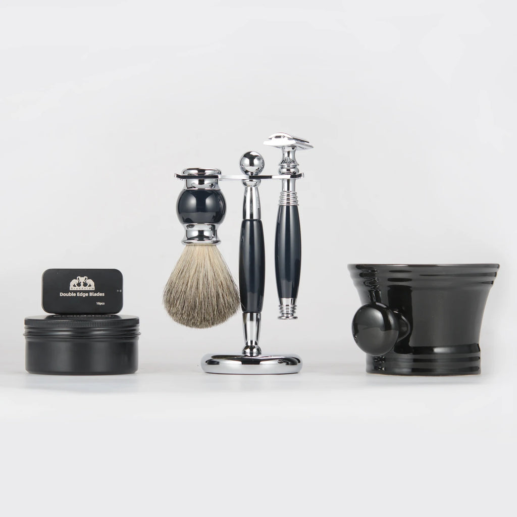 Traditional shaving set with a chrome and black razor, badger hair brush, metal stand, soap tin, and black shaving bowl.