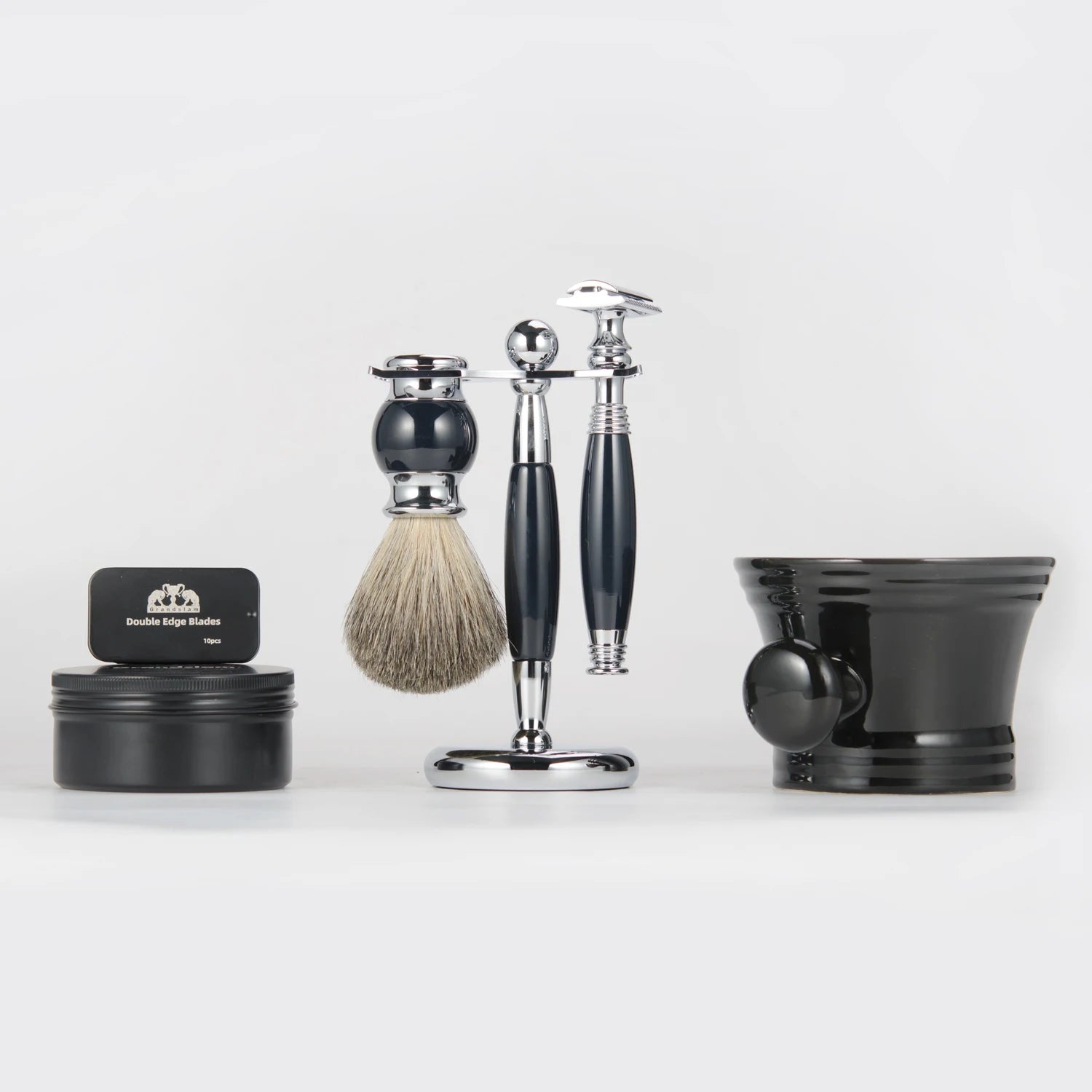 Traditional shaving set with a chrome and black razor, badger hair brush, metal stand, soap tin, and black shaving bowl.