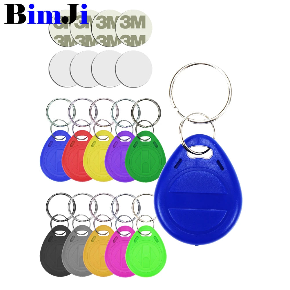 Multi-colored plastic RFID key fob tags with metal split rings and adhesive circular stickers on a white background.