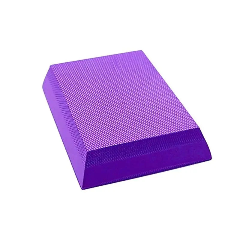 Purple foam yoga balance pad with a textured, non-slip surface for stability and exercise.