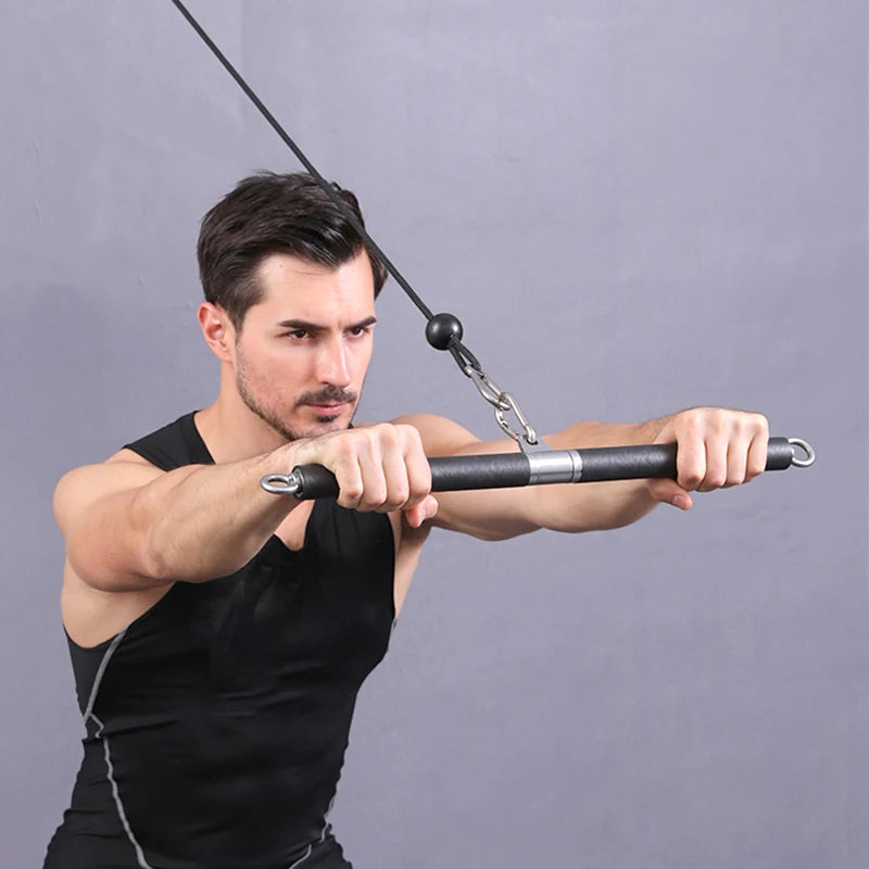 A man in a black tank top pulls down on a straight cable machine bar with both hands.