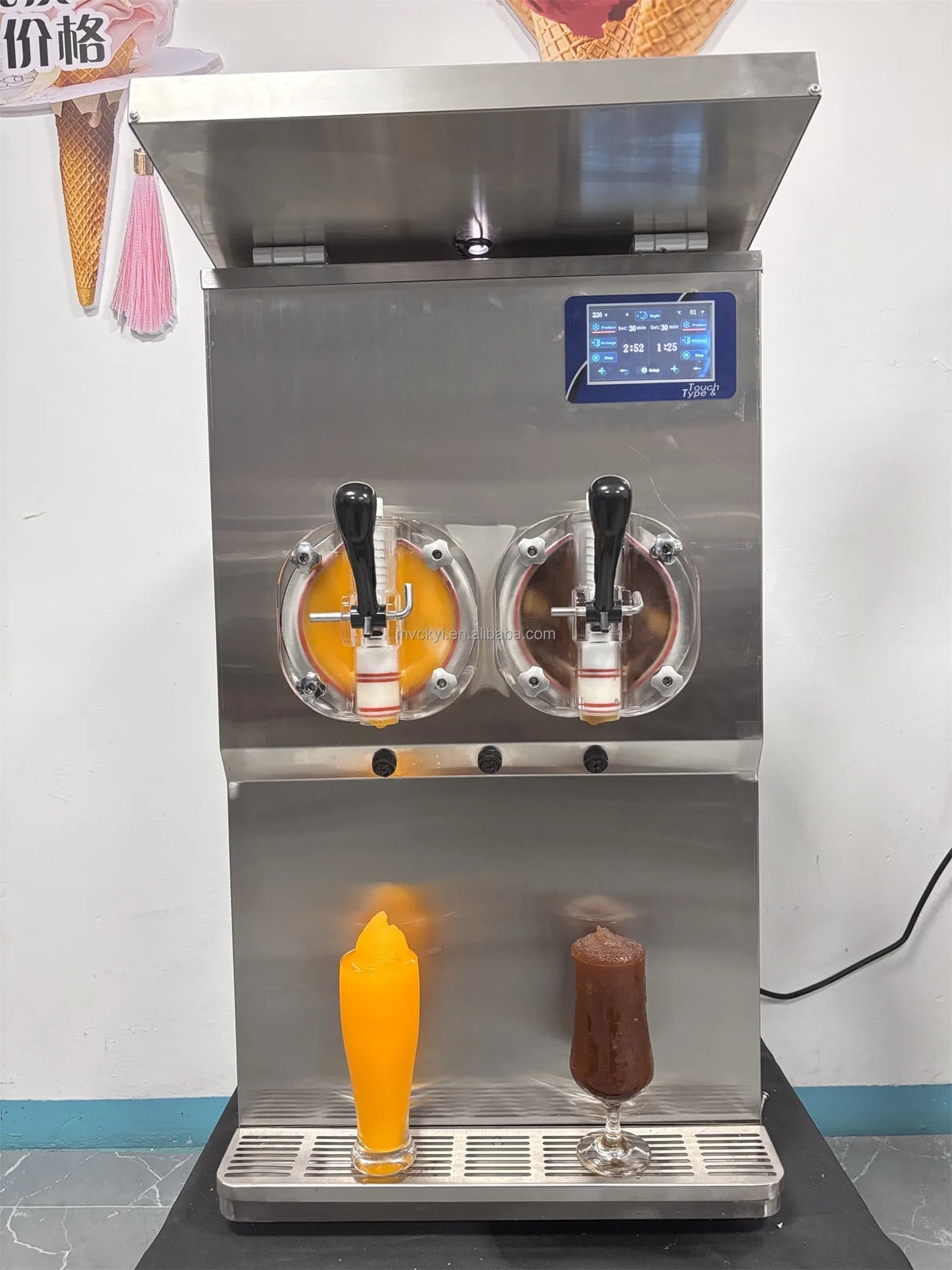 Stainless steel commercial slushy machine with two tanks, black dispensing handles, digital display, and drip tray.