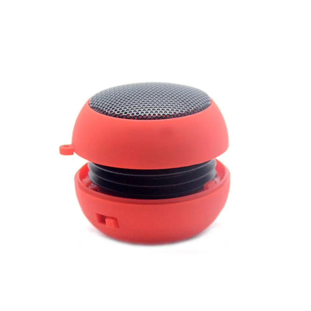 Compact, spherical red portable speaker with a black metallic grille and an extendable accordion-style body.