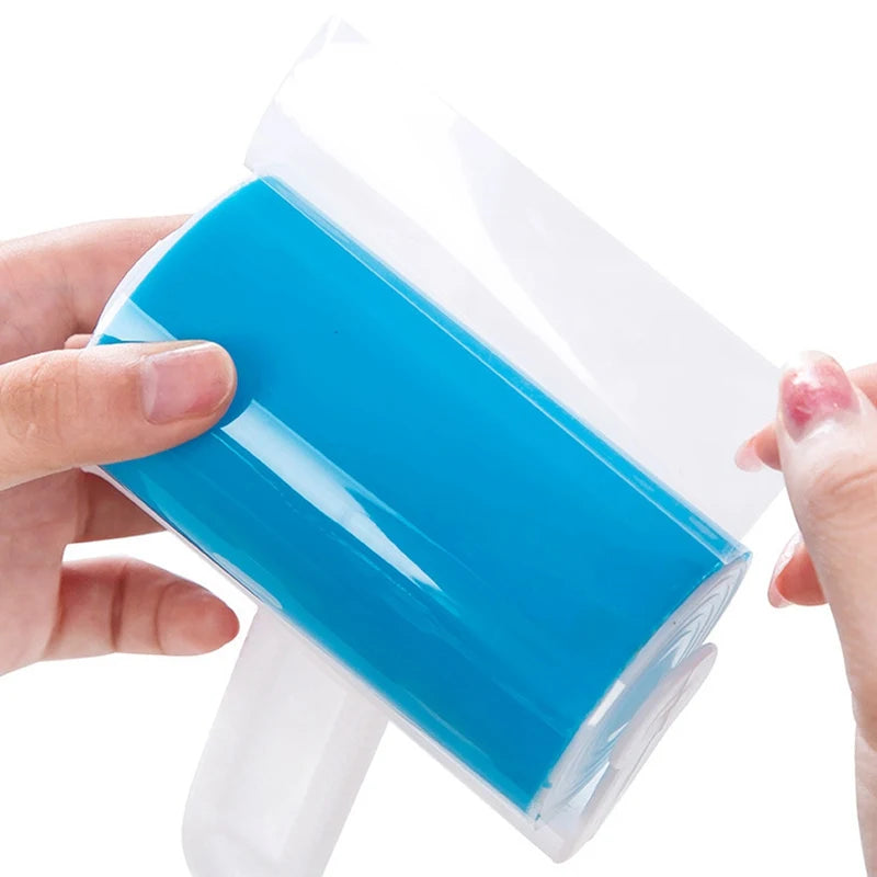 Hands peeling a clear adhesive sheet from a bright blue sticky lint roller on a white background.