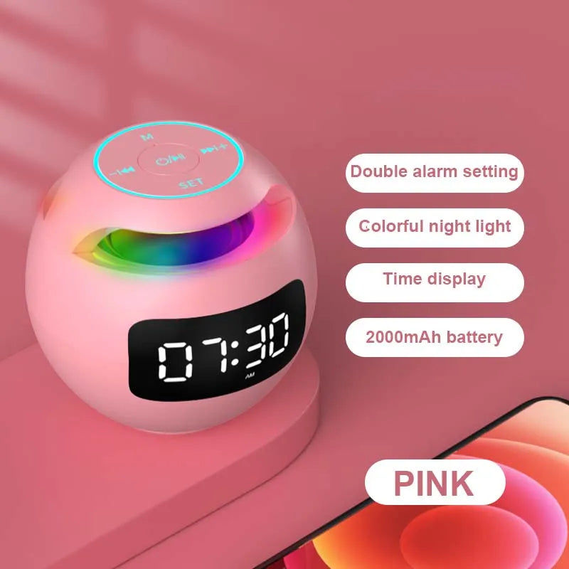 A round, pink Bluetooth speaker and LED alarm clock with a digital display, colourful light effect and top controls.