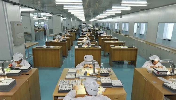 Skilled workers assembling ultra-thin stainless steel quartz watches in a bright, modern precision workshop.