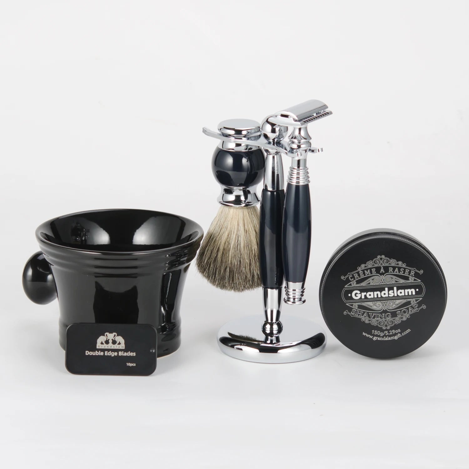 Traditional shaving set with a chrome safety razor, badger hair brush, black bowl, shaving soap, and blade case.