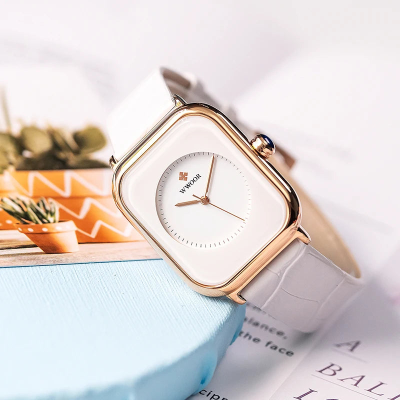 Ladies' fashion watch with a white leather strap, rose-gold square case, and white circular analogue dial.