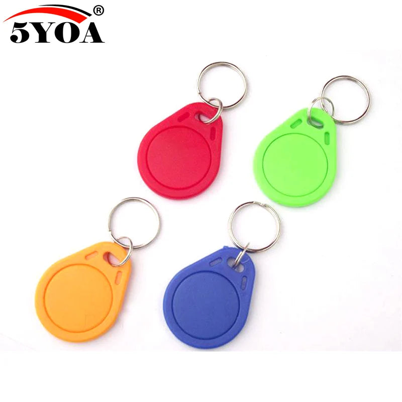 Four circular plastic RFID key fob tags in red, green, orange, and blue with attached metal key rings.
