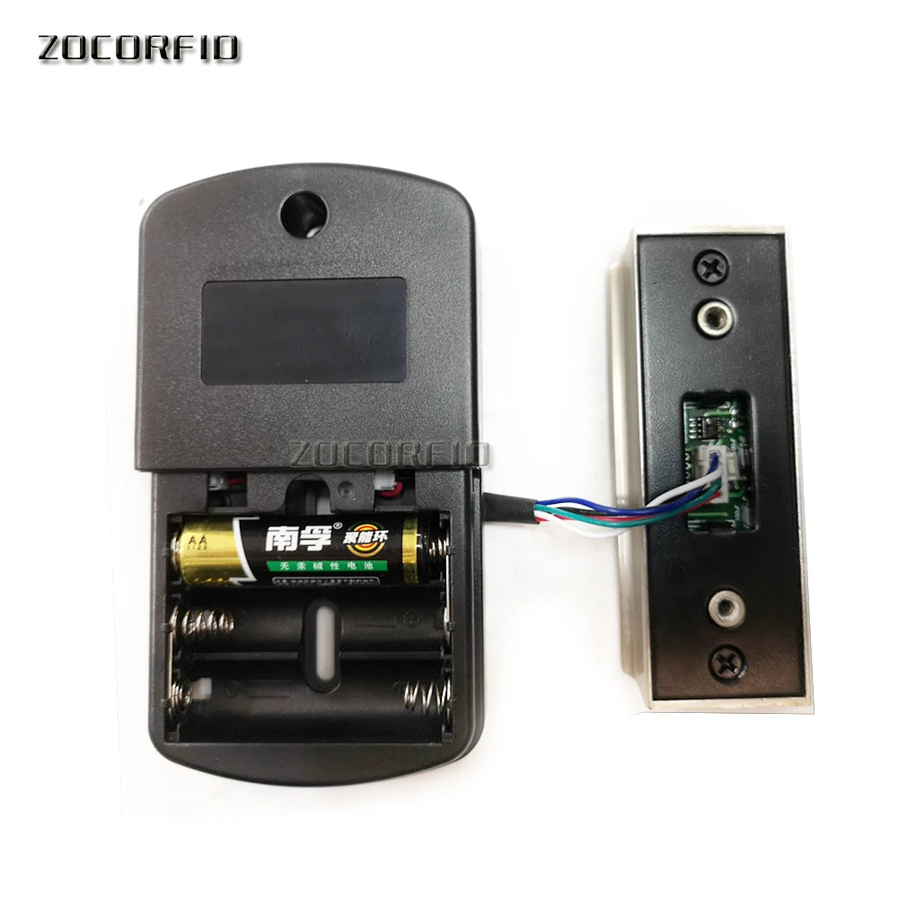 Black plastic electronic door lock unit with battery compartment, AA battery, and connected metal sensor panel.