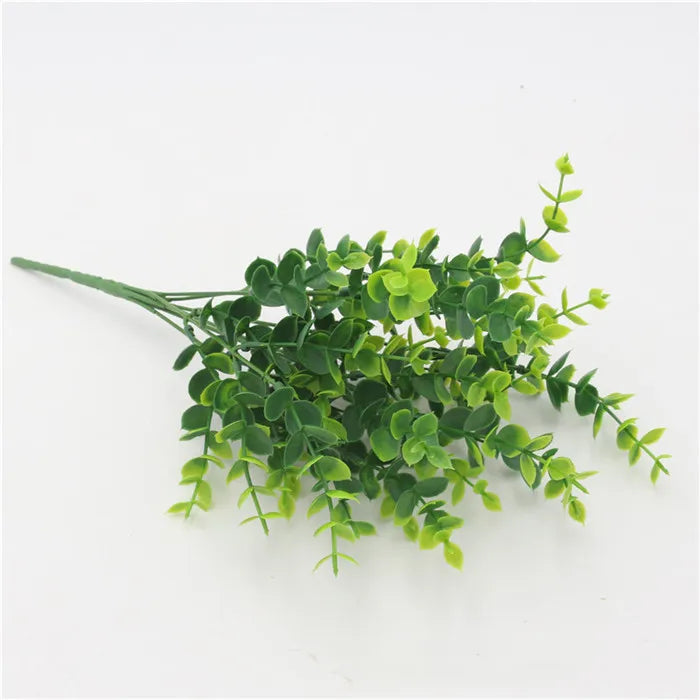 Artificial eucalyptus-style plant stem with small, layered green leaves, set against a plain white background.